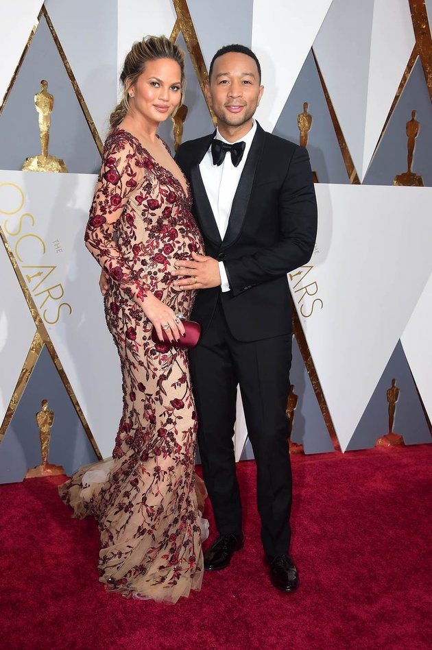 Ada John Legend dan Chrissy Teigen. Chrissy selalu setia temani sang suami ke manapun ia pergi meski sedang hamil besar.
