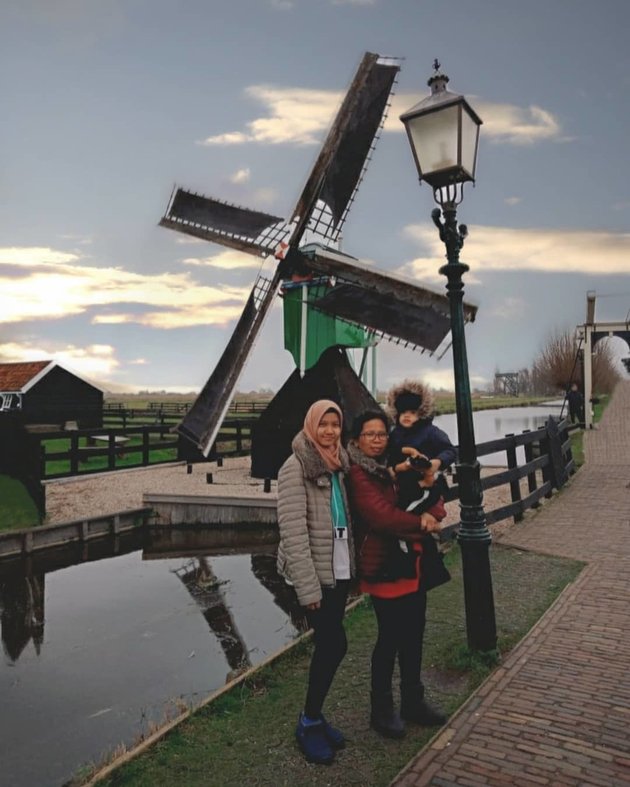 Berpose dengan latar belakang kincir angin ketika berada di Belanda. Itu juga ada Suwarsih Asih, pengasuh Arsy sejak kecil.