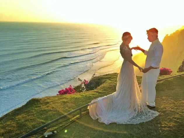 Di atas tebing pantai Uluwatu, dengan lanskap pantai dan matahari terbenam, Gading dan Gisel menikmati momen romantis mereka.