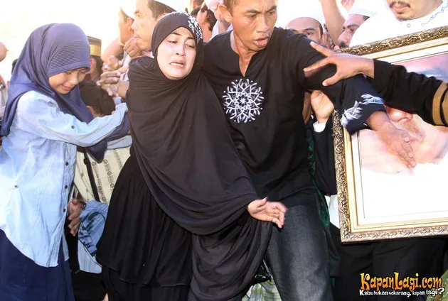 Pipik tak kuasa menahan air mata saat Uje akan dimakamkan.