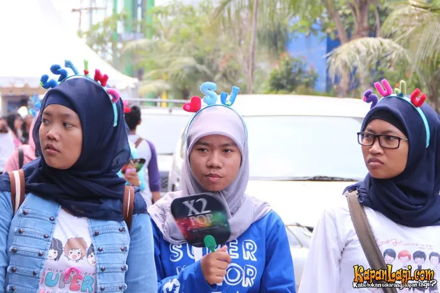 Tiga orang ELF ini nampak memamerkan tiga bando yang berbeda, SS4 INA, tanda cinta dan tulisan SJ, serta SuJu.