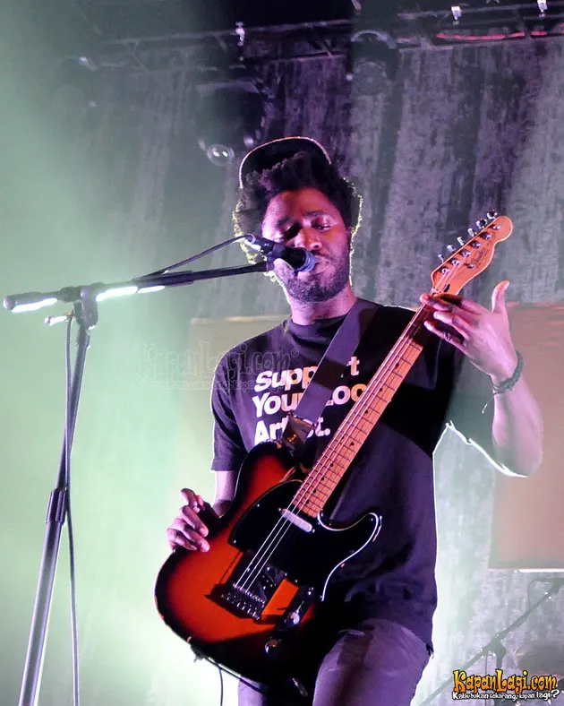Kele Okerele (vokal, gitar) terlihat keren menggenakan topi.