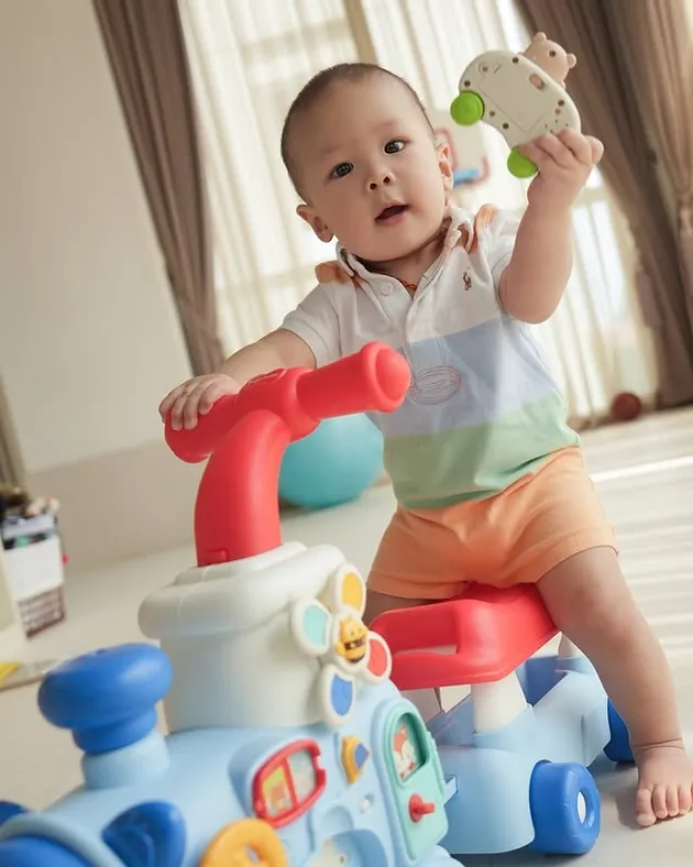 Nael anak Nikita Willy duduk di atas mainan