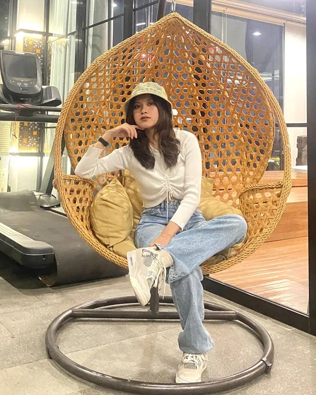 Risa Amel duduk di ayunan rotan