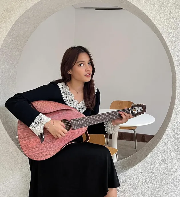 Aruma bermain gitar akustik