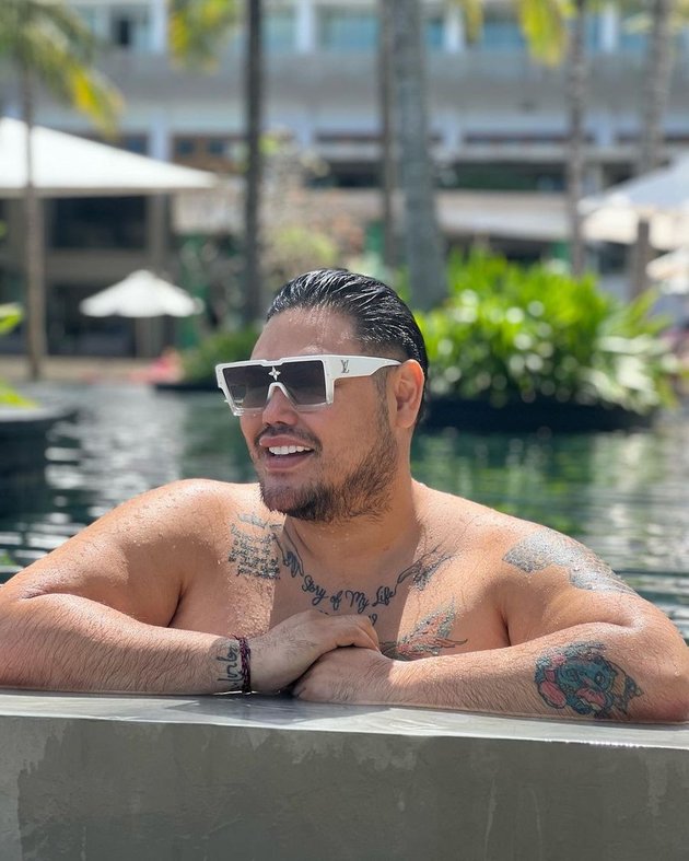 Portrait of Ivan Gunawan who Looks More Macho with Mustache and Thick Beard, Bare Chested Showing Tattoos on His Body and Netizens Focus on His Arm Hair
