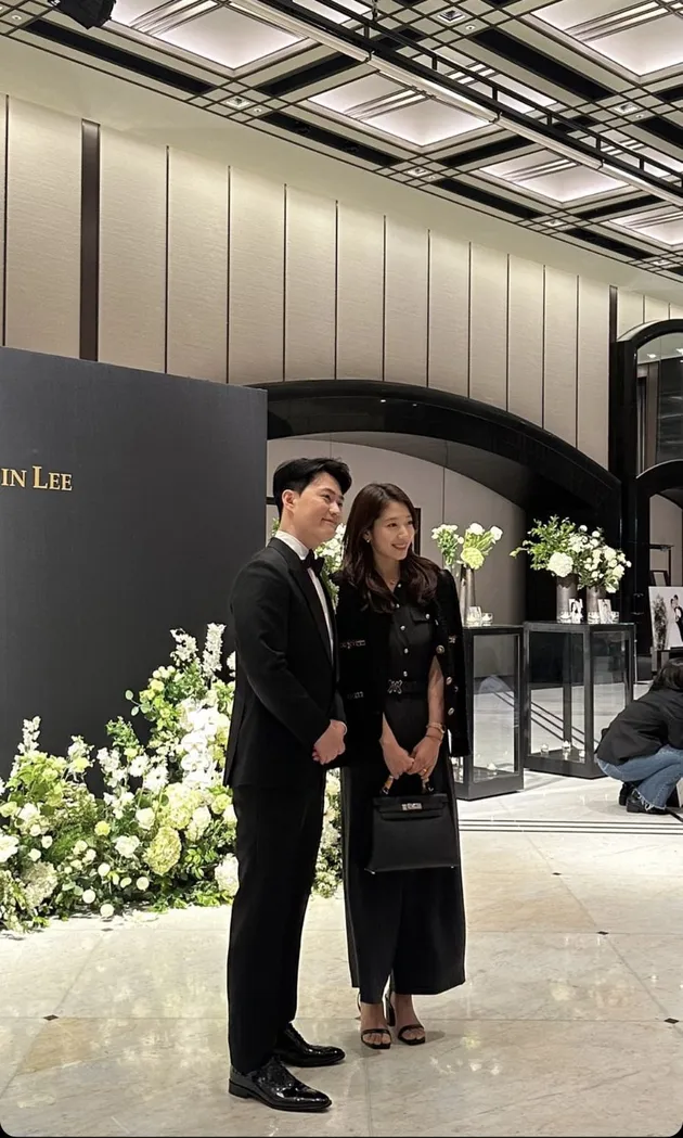 Park Shin Hye ketika berpose dengan mempelai pengantin. Ia memilih memakai dress panjang simple dengan cardigan. Semuanya serba hitam.