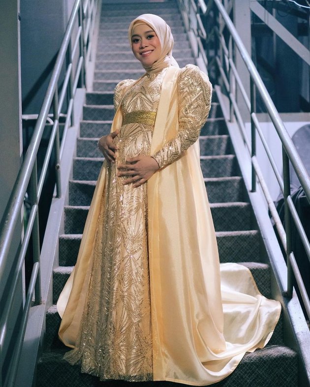 Lesti tampil memesona dengan gaun emas panjang. Padu padan pedangdut asal Cianjur ini diatur oleh fashion stylist Wanda Hara.