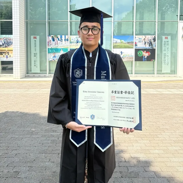 Rafly Azis pakai toga pegang ijazah