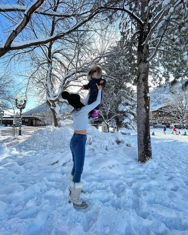 Shandy Aulia's Photos Playing in the Snow in Aspen, Learning to Ski - Relaxing while Wearing a Crop Top to Show Her Stomach in the Middle of the Snow