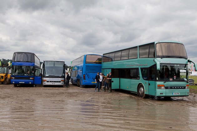 Mengapa para artis tersebut harus memakai boots? Lihatlah lautan bus yang parkir di tengah lautan lumpur ini...