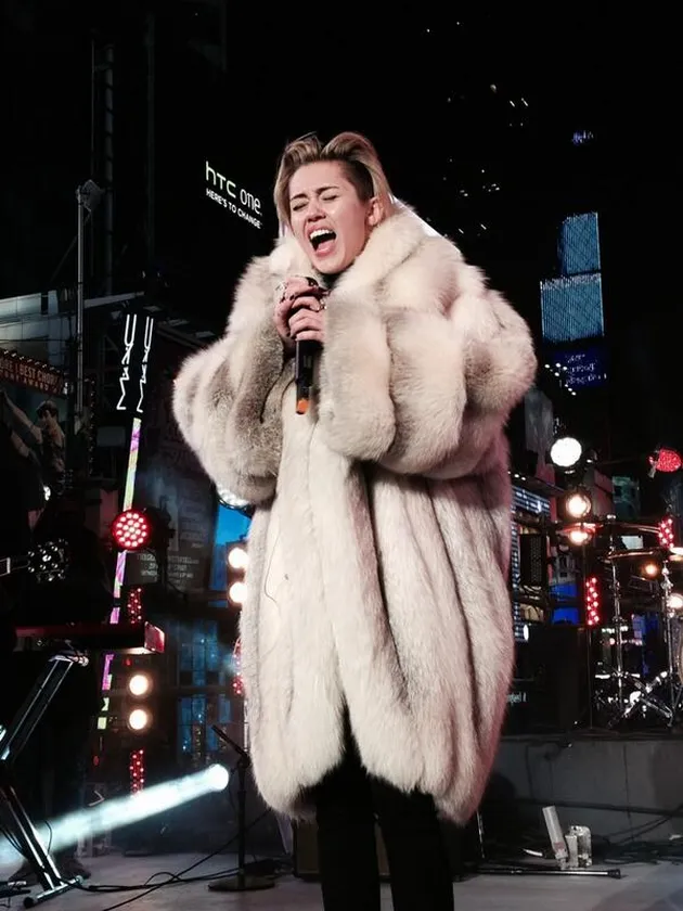 Miley Cyrus tampil megah dengan memakai jubah putih berbulu tebal. Hal itu cukup wajar, karena suhu udara di Times Square menggigit.