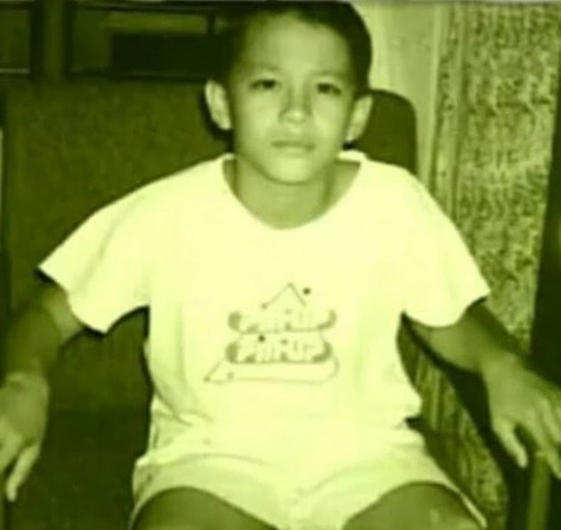 Foto-foto Ariel saat masih kecil ini jarang diketahui oleh publik lho. Seperti foto ini, Ariel yang sedang duduk santai dan memakai baju serta celana pendek warna putih, ekspresinya pun datar.