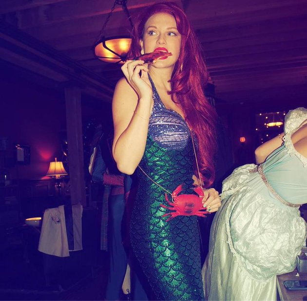 Taylor Swift hampir sulit dikenali saat mengenakan wig berwarna merah. Malam itu ia berdandan ala Ariel si Little Mermaid.
