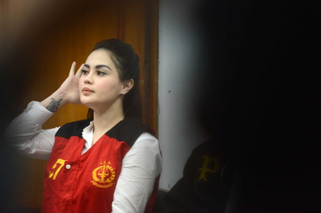 Jennifer Dunn malah menggunakan headset sambil menunggu persidangan dimulai © KapanLagi.com/Bayu Herdianto