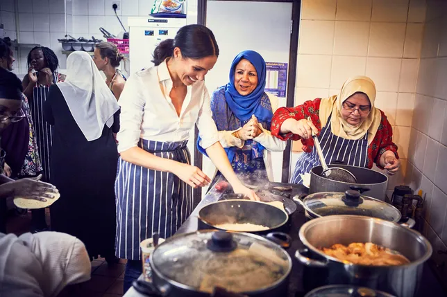 Meghan terjun langsung dengan membantu ibu-ibu di dapur © AFP