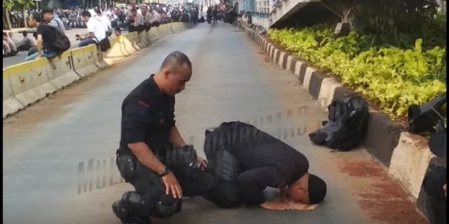 Jaga Unjuk Rasa, Petugas Polisi Sempatkan Salat Dhuhur Jamaah di Pinggir Jalan