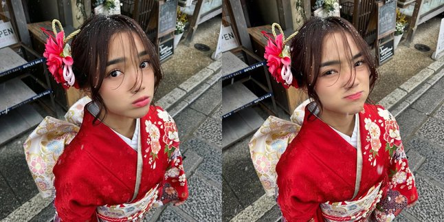 Beautiful Portrait of Fuji Wearing a Red Kimono While on Holiday in Japan, Looking Enchanting Amidst Snowflakes