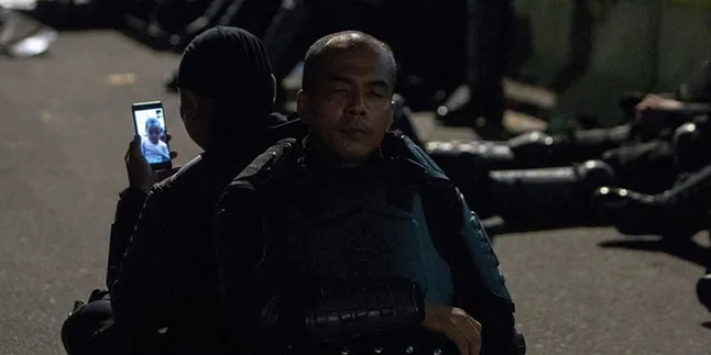 Tengah Berjaga di Depan Bawaslu, Polisi Ini Sempatkan Video Call dengan Anak