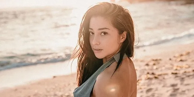 Membelakangi Kamera Dalam Balutan Bikini, Nikita Willy Santai Dayung Papan Selancar Saat Liburan di Pulau Wayag