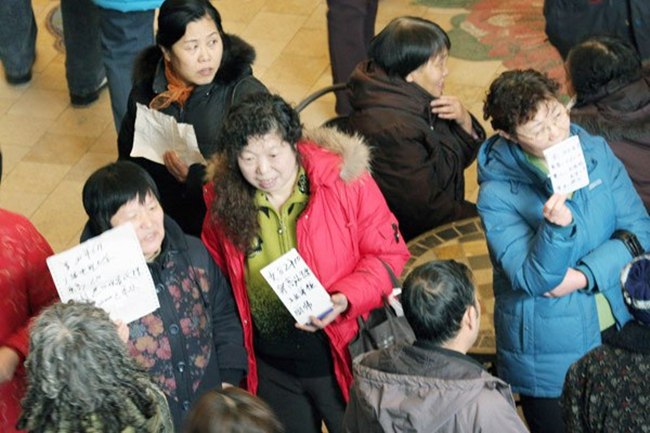 Para ibu membawa kertas bertuliskan biodata anaknya saat datang ke pameran pernikahan | foto: copyright chinadaily.com.cn