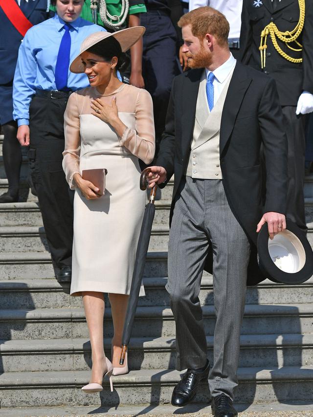 Duke dan Duchess of Sussex, Pangeran Harry dan Meghan Markle menghadiri pesta kebun Istana Buckingham di London, Selasa (22/5). Meghan juga memakai stocking warna kulit, mengikuti cara berbusana Putri Inggris lainnya. (Dominic Lipinski/Pool Photo via AP)