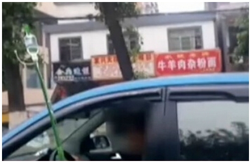 Seorang wanita berkendara dalam keadaan masih diinfus. | Foto: copyright shanghaiist.com