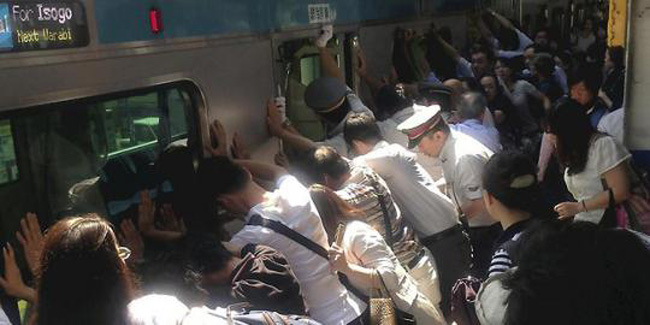 Potret penumpang bersama-sama menolong wanita yang terjepit | (c) asiadailywire.com