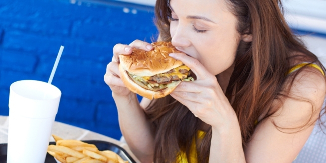 Wanita menghindari makan junk food di depan pria yang disukainya/copyright Shutterstock.com