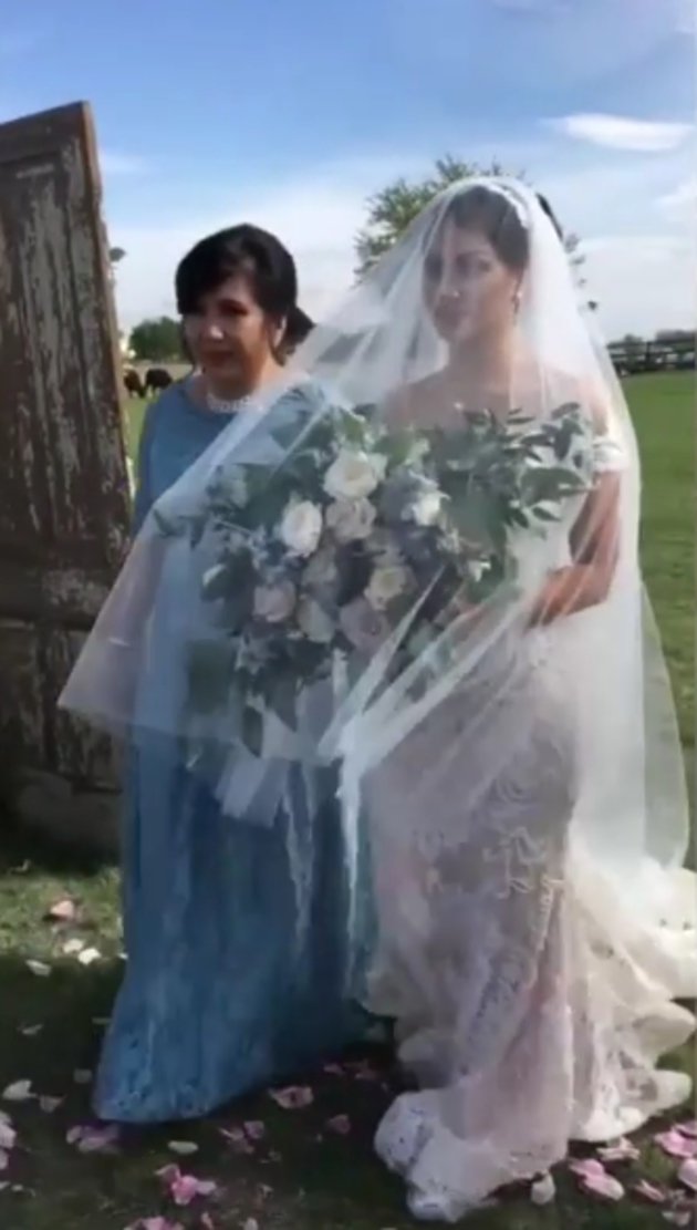 Denalta memasuki lokasi pernikahan dengan didampingi oleh bridesmaid-nya. Finalis Miss Indonesia 2013 ini nampak cantik dengan gaun putih dan buket bunga di tangannya./instagram.com/aliciamilka